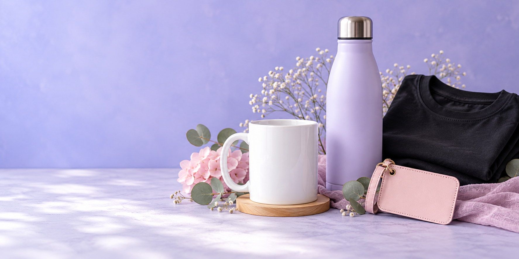 Tasse blanche, bouteille lilas, chandail noir et étiquette cadeau dans un décor créatif.